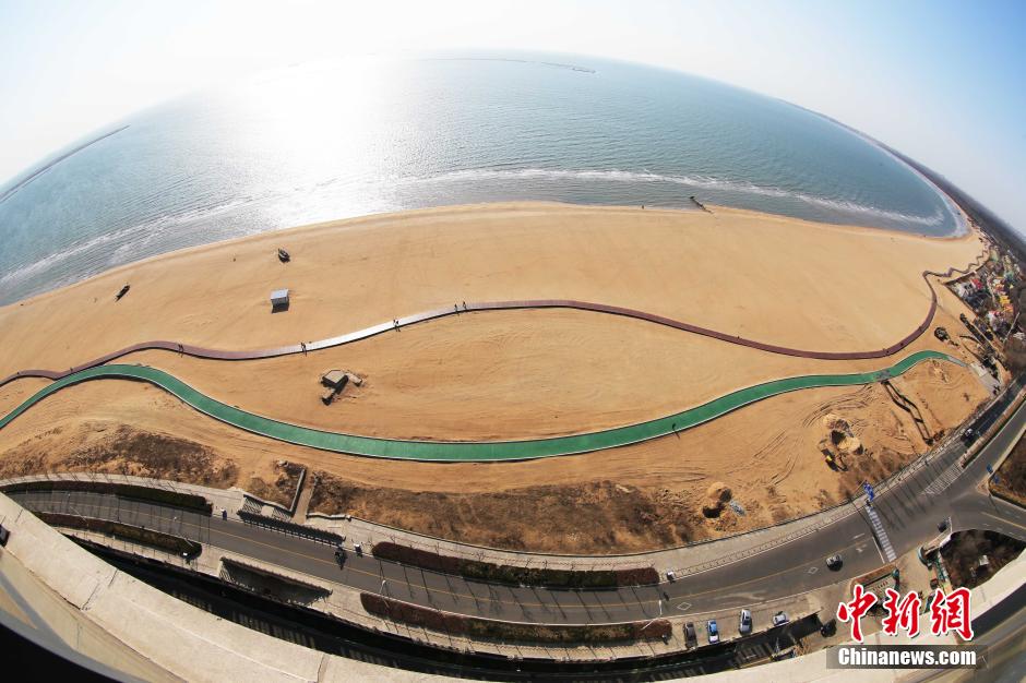 3月13日，秦皇島萬米臨海沙灘木棧道。據(jù)了解，該木棧道全長約4200米，與北戴河區(qū)原有的7500米木棧道對(duì)接后全線總長度1.17萬米，整個(gè)木棧道東起秦皇島體育基地游船碼頭，西至北戴河濕地公園，呈波浪形蜿蜒10.4公里海岸線。 中新社發(fā) 曹建雄 攝 CNSPHOTO